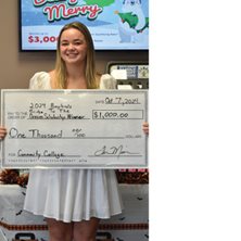 Scholarship winner holding up a large check