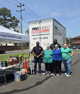 Team members standing in front of a big box truck that says Pro Shred Security, gearing up for the Shred-A-Thon event